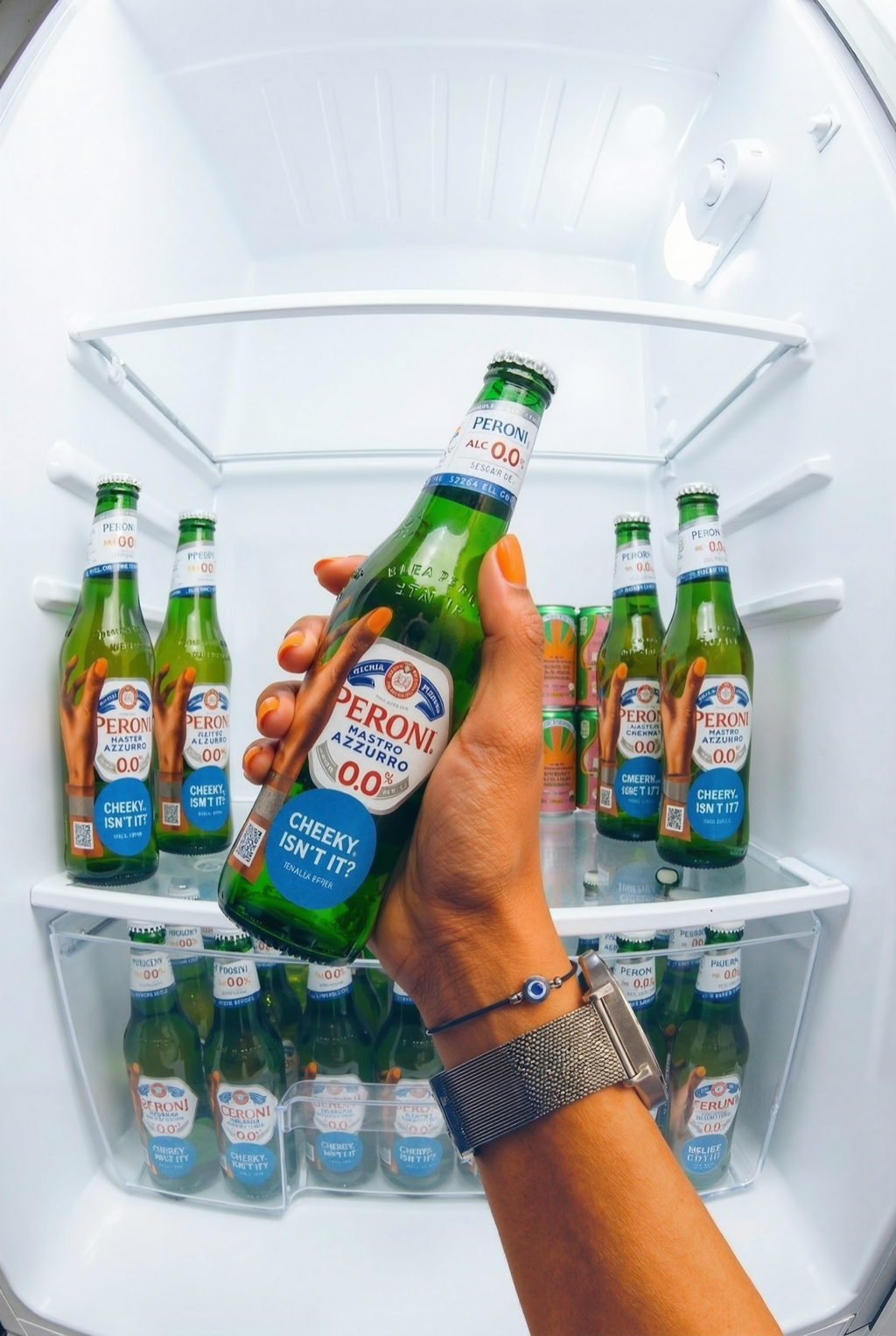 A hand holding a Peroni 0.0 bottle inside a fridge full of bottles